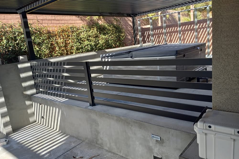 An outdoor hot tub surrounded by a 4K Aluminum fencing installation