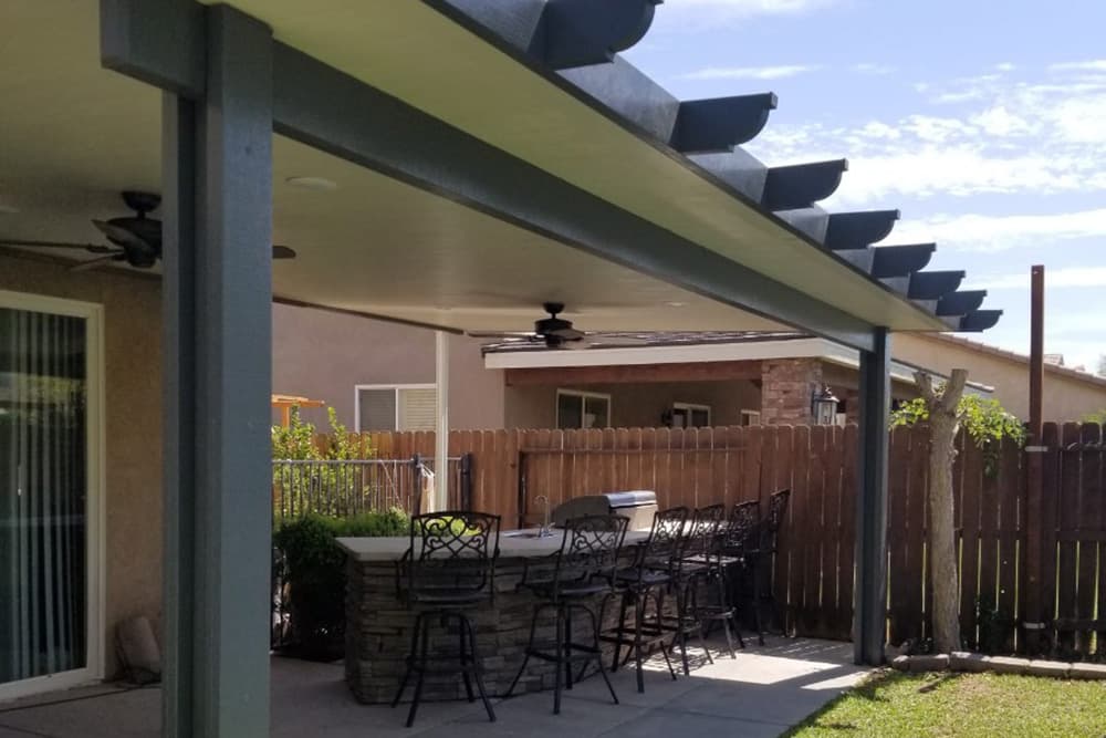 A view of an outdoor living and BBQ space with a solid patio cover